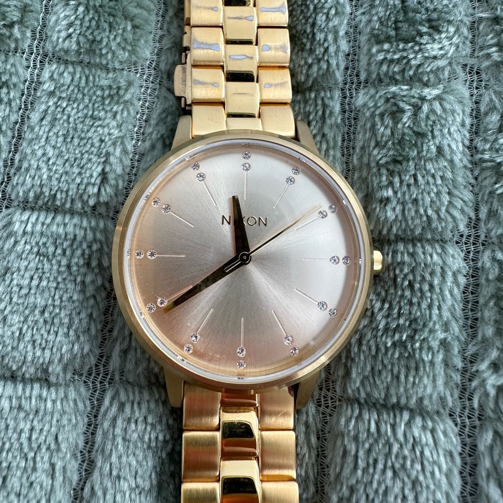 Gold Nixon watch with rhinestones.
